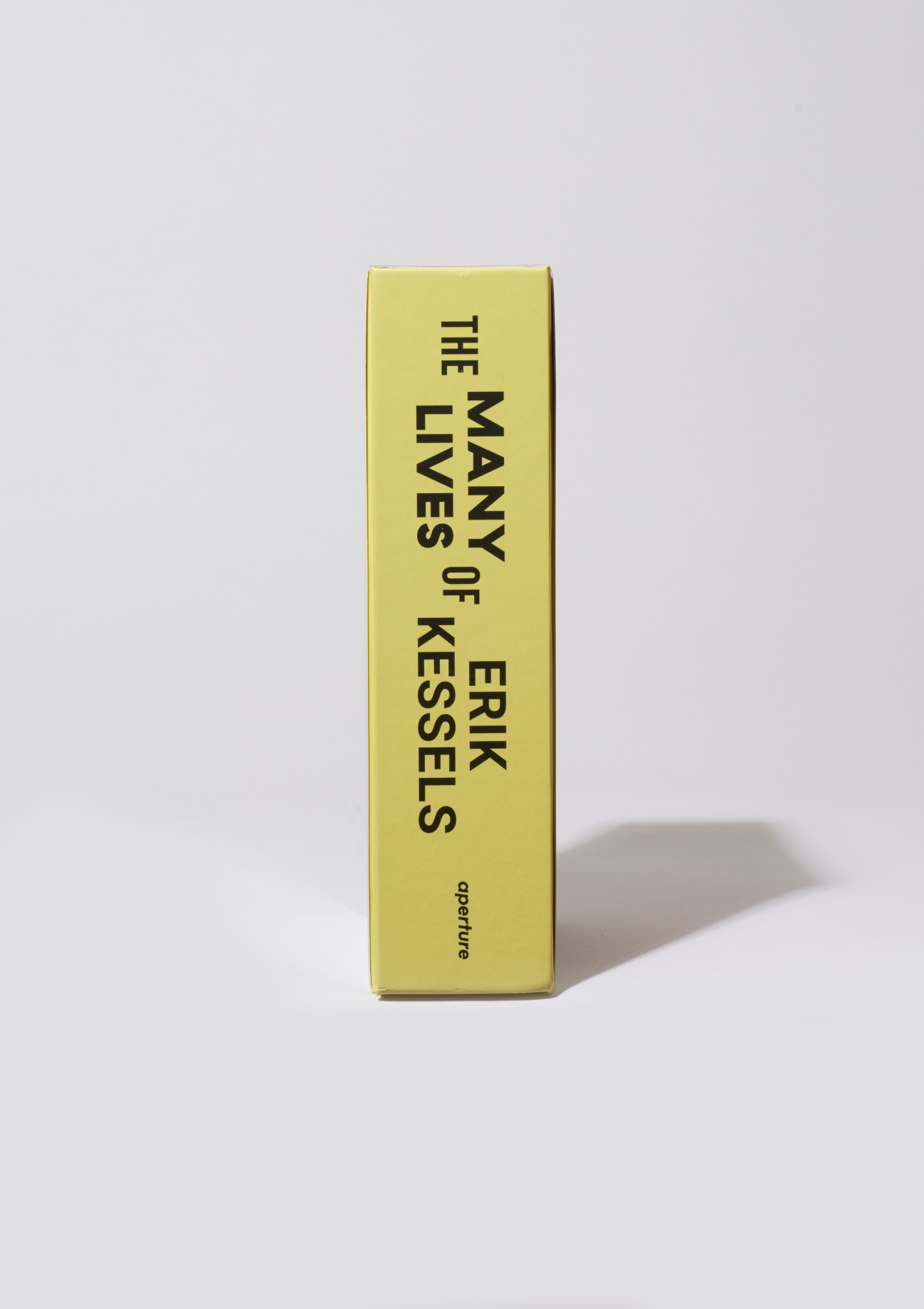 Yellow book cover titled 'The Many Lives of Erik Kessels' by Aperture.