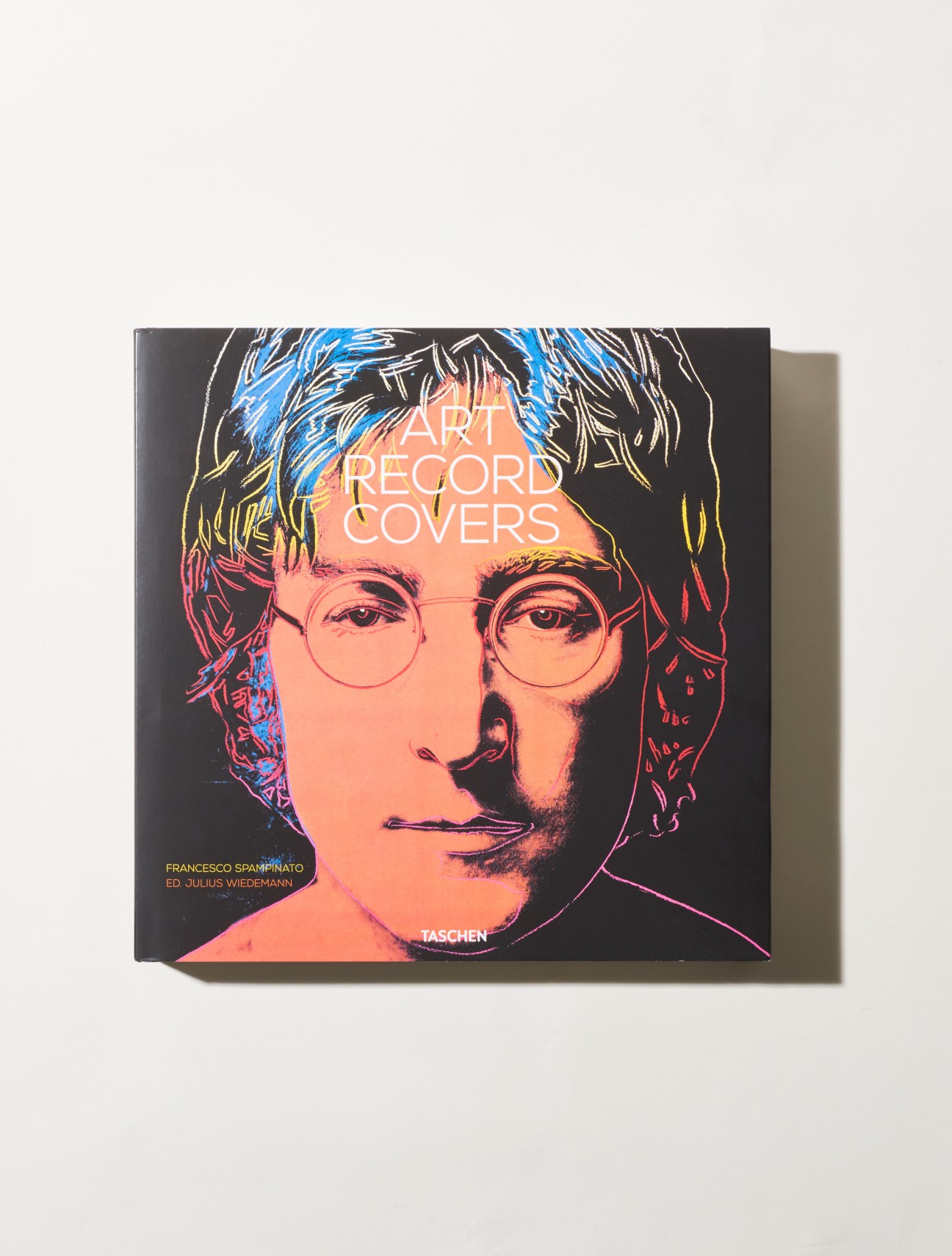 Art Record Covers book cover by Taschen featuring colorful pop art portrait of a person with round glasses