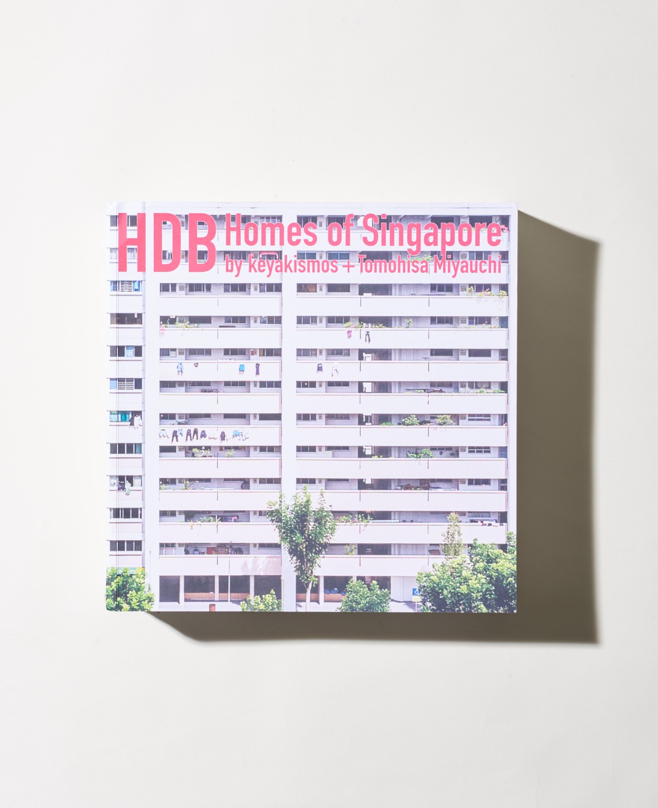 Book cover for HDB Homes of Singapore by Keyaskimos and Tomohisa Miyauchi featuring a residential tower facade.