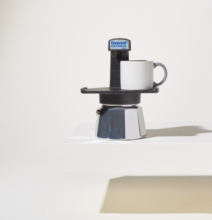 Gemini Express stove-top espresso maker with white cup on neutral background.