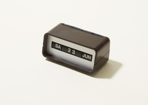 Vintage Arlac desk calendar in brown with rolling mechanism showing day, date and month.
