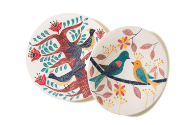Two decorative ceramic plates with colorful Iranian folk art designs featuring birds and flowering trees.