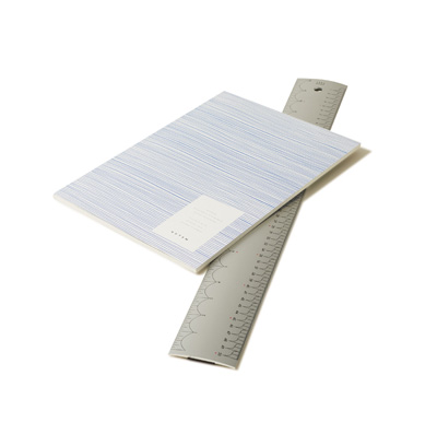 Aluminium ruler and blue notebook on white background