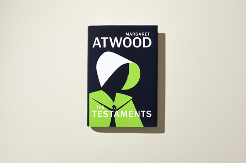 Book cover of Margaret Atwood's "The Testaments" featuring black background with white and lime green design elements.