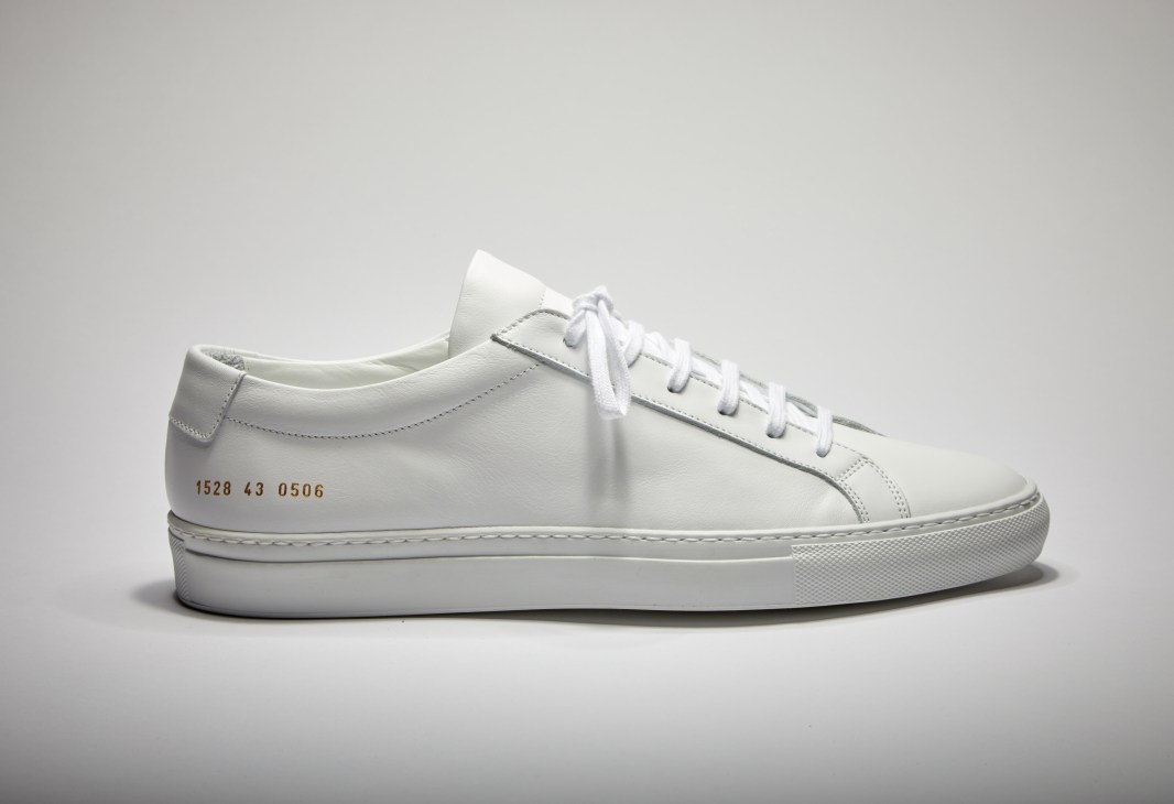 White leather low-top sneaker with white laces and serial number printed on the side.