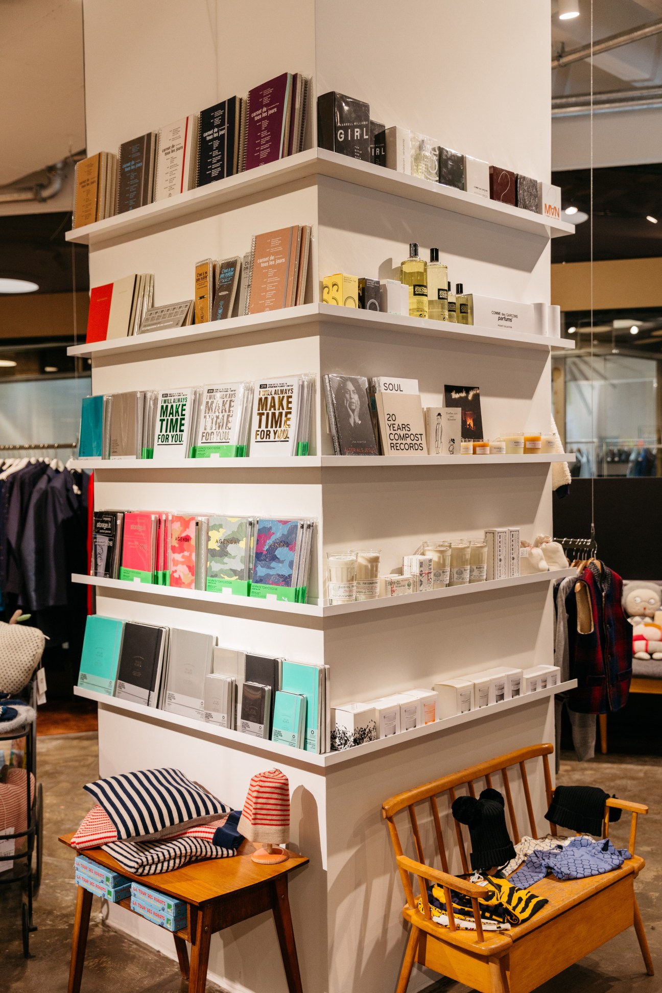 White shelving display with books, beauty products, and home goods in a modern retail interior.