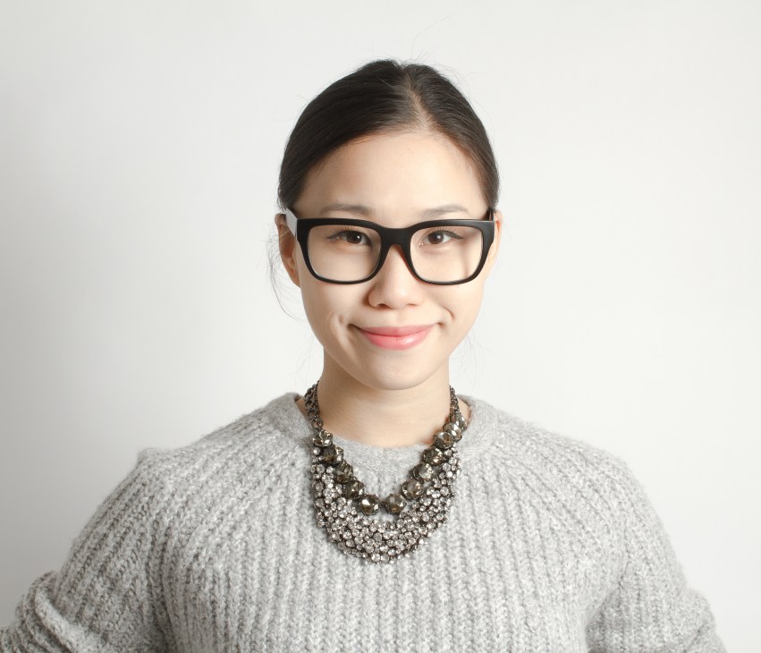 Portrait of Rosa Park, editor of Cereal magazine, wearing glasses and a grey sweater with a decorative necklace.