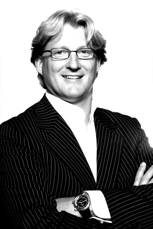 Black and white portrait of Frans Otten, founder of Lemnis Lighting, wearing glasses and a pinstriped suit.