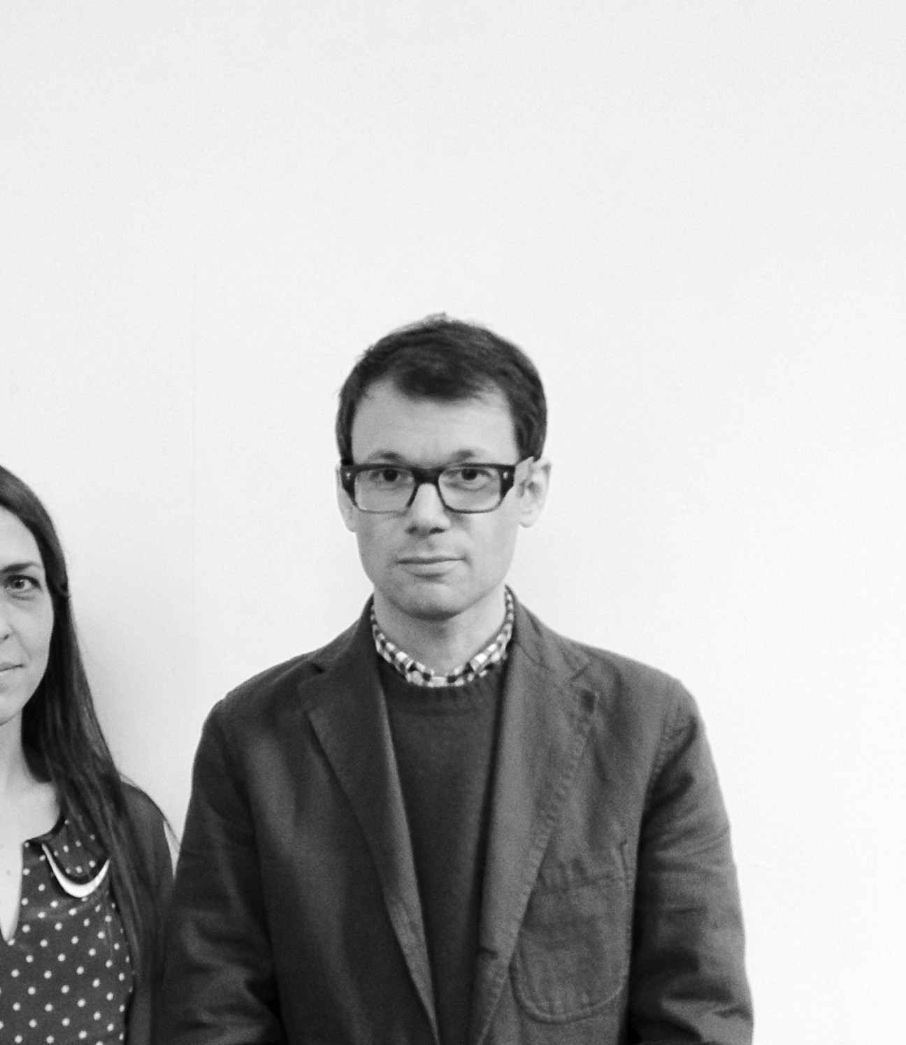 Black and white portrait of Ben Olins, co-founder of Herb Lester, wearing glasses and a checkered shirt.