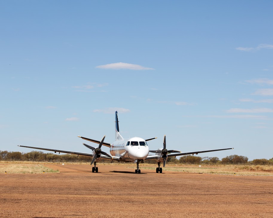 Regional Express Saab 340 aircraft parked on runway at Windorah Airport in Queensland outback.