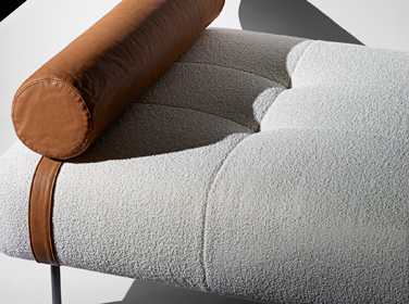 Erei daybed by De Padova with brown leather cylindrical headrest and light grey upholstered seat.
