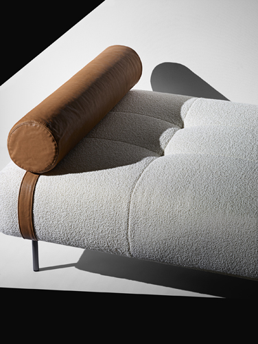 Erei daybed by De Padova with brown leather cylindrical headrest and light grey upholstered seat.