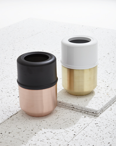Two cylindrical containers with contrasting finishes, one in rose and brass, one in white and brass.