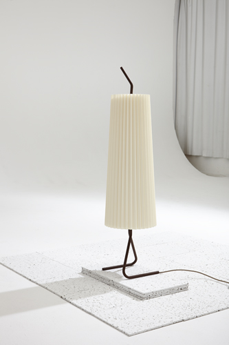 Fliegenbein SL lamp with cream pleated shade and curved dark metal base on white surface.