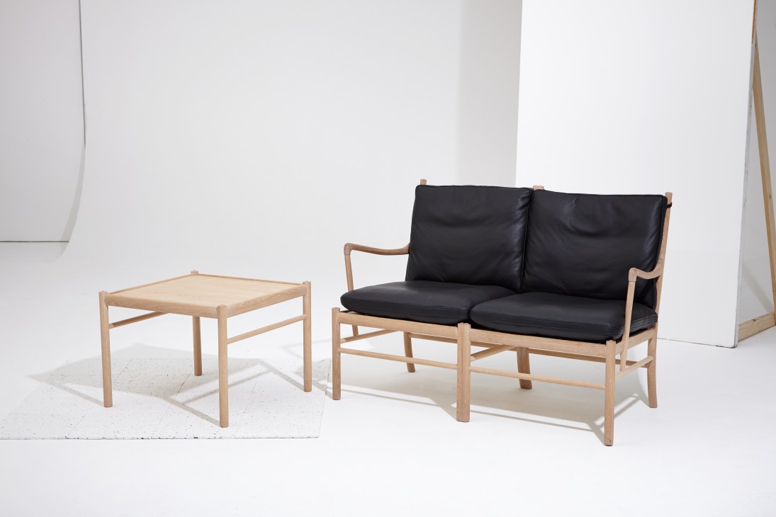 Colonial sofa and coffee table by Carl Hansen & Søn, featuring natural wood frame with black cushions and minimal design.