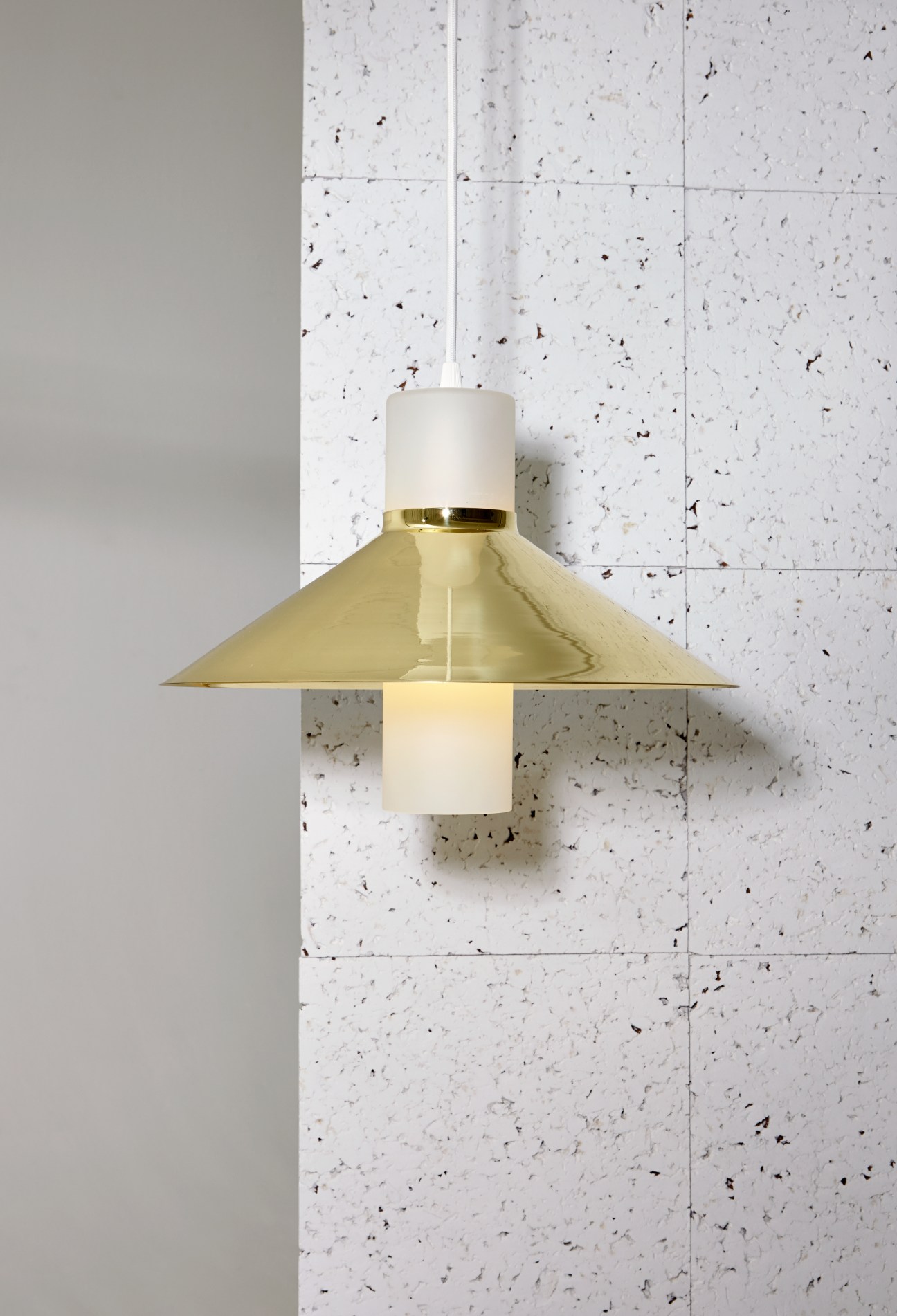 Noble & Wood Cape pendant light with brass conical shade and matte glass column.