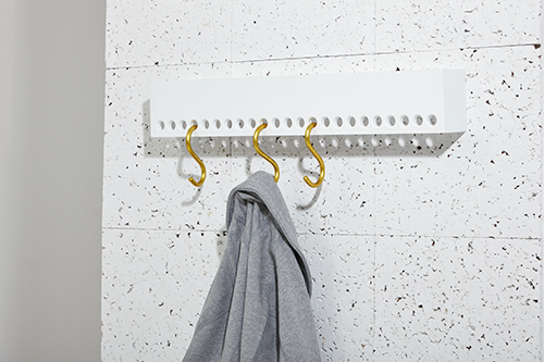 So-Hook wall rack by Nomess with S-hooks and shelf holding a gray garment on a white speckled wall.