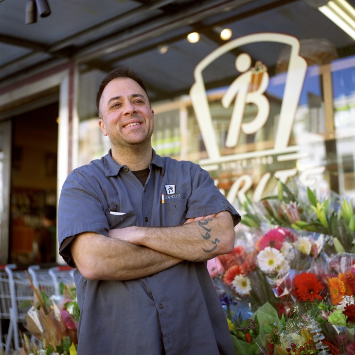 Sam Mogannam, owner of Bi-Rite market, standing outside the store with arms crossed.