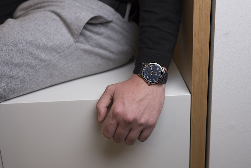 Nomos Glashütte Club Campus watch with rose-gold hands and textile strap worn on wrist.