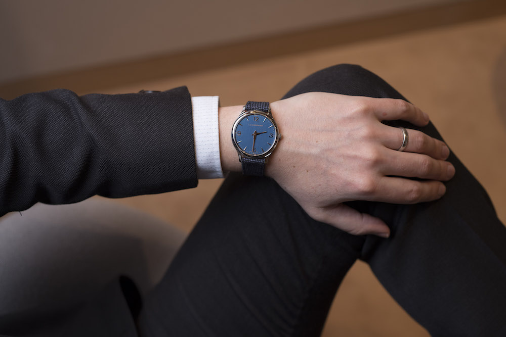 Person wearing a Chopard LUC XP watch with navy dial and merino-wool strap on their wrist.