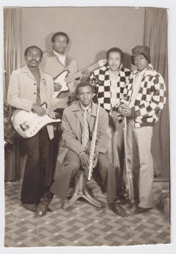 The Scorpions & Saif Abu Bakr, a Sudanese funk-jazz band, pose together with instruments in a studio setting.