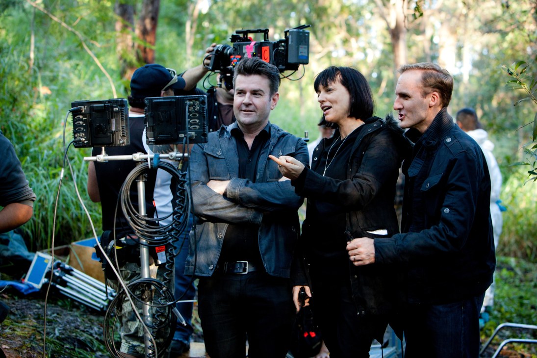 Film crew and director on set filming Secrets & Lies in a forest location