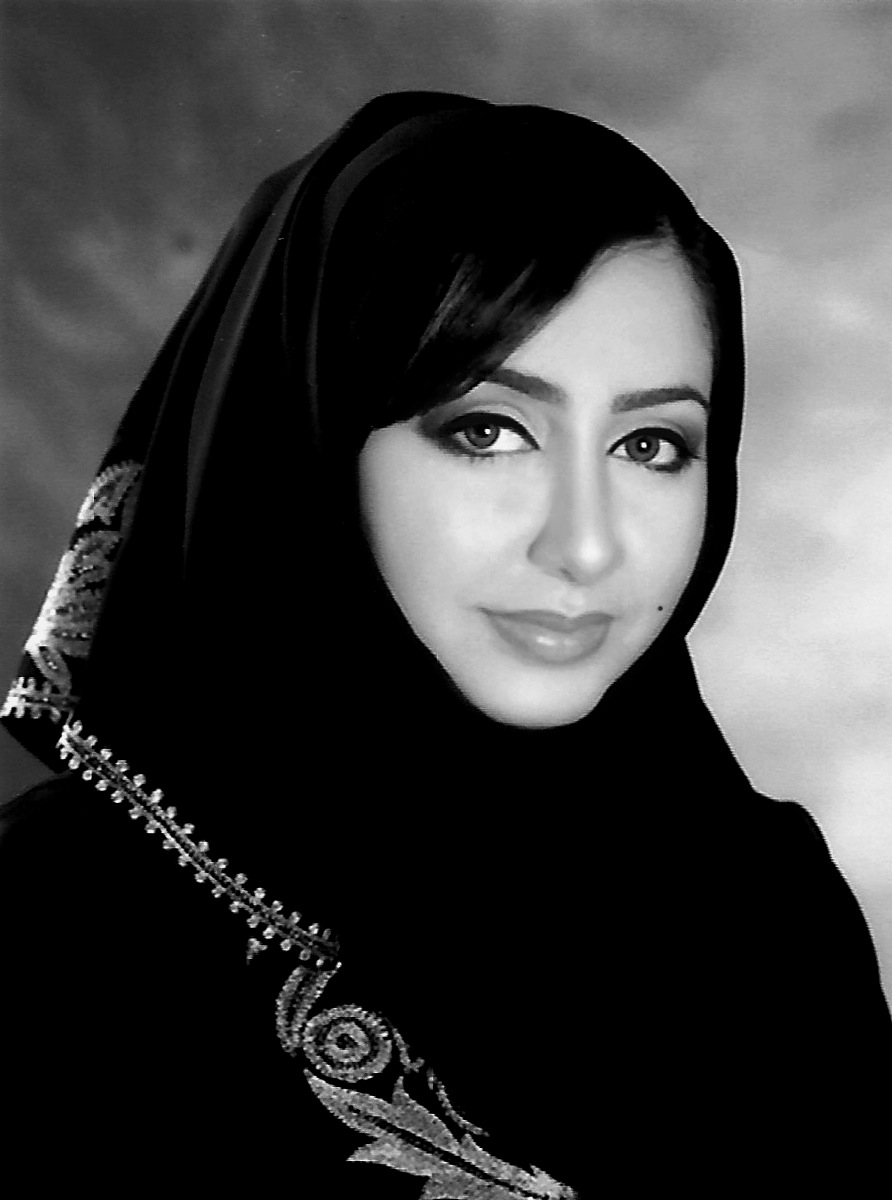 Black and white portrait of Sheikha Al Maskari, Vice President of Corporate Affairs at Abu Dhabi International Airport, wearing a black headscarf with embellished details.