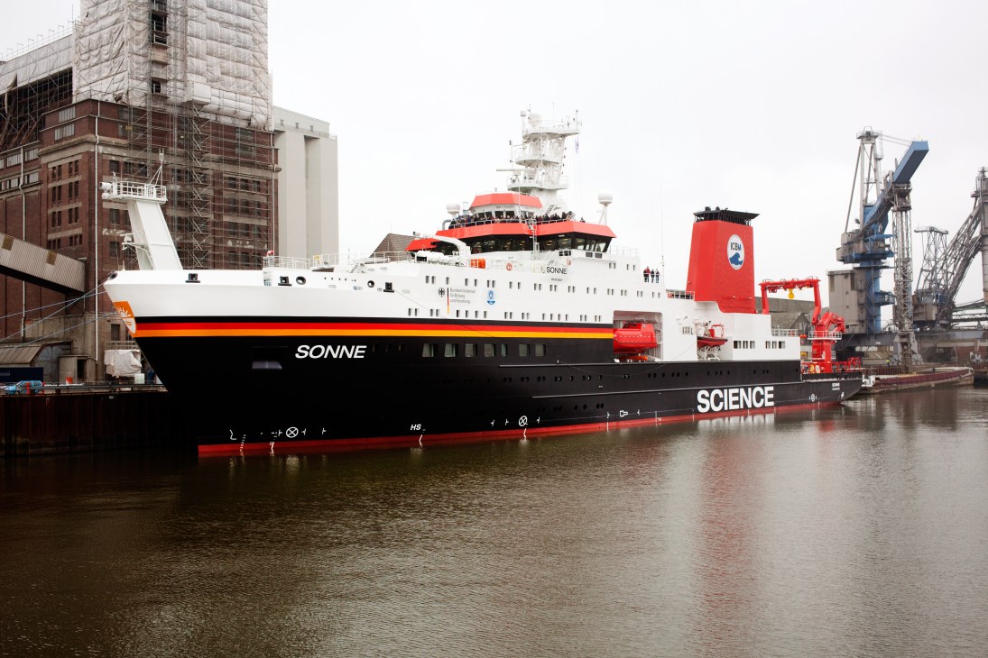 Research vessel Sonne docked in harbor with German flag colors on hull.