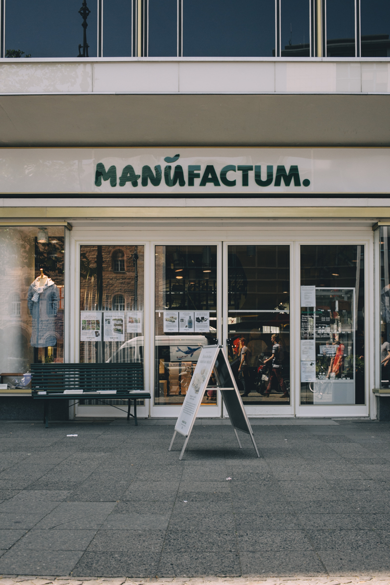 Manufactum storefront in Berlin with green signage and large windows displaying products.