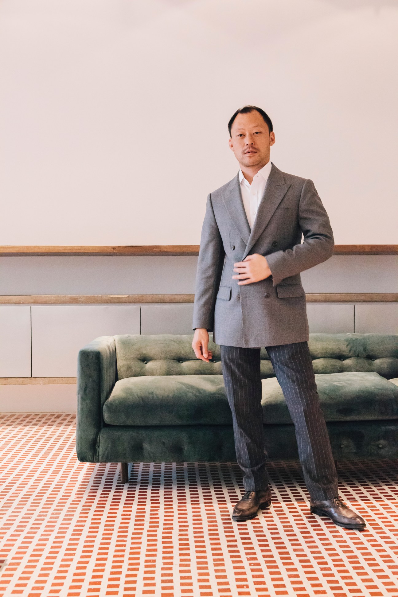 Sorapoj Techakraisri, CEO of Pace Development, standing in a modern interior space with geometric patterned flooring.