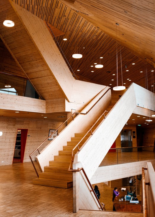 Interior of the Global Seed Vault entrance with wooden cladding, angular white staircase, and modern pendant lighting.