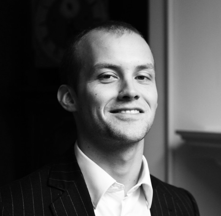 Black and white portrait of Toby Matthiesen, a man in a pinstriped jacket and white shirt.