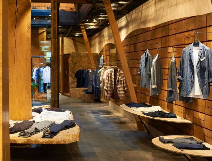 Interior of 45R clothing store displaying indigo-dyed garments and casual wear on wooden wall displays and clothing racks.