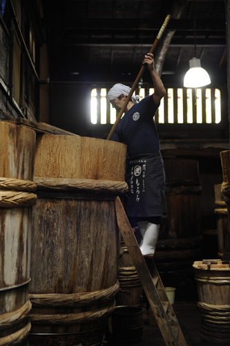 Traditional interior of Sawai Shoyu Honten soy sauce brewery in Kyoto showing wooden fermentation barrels