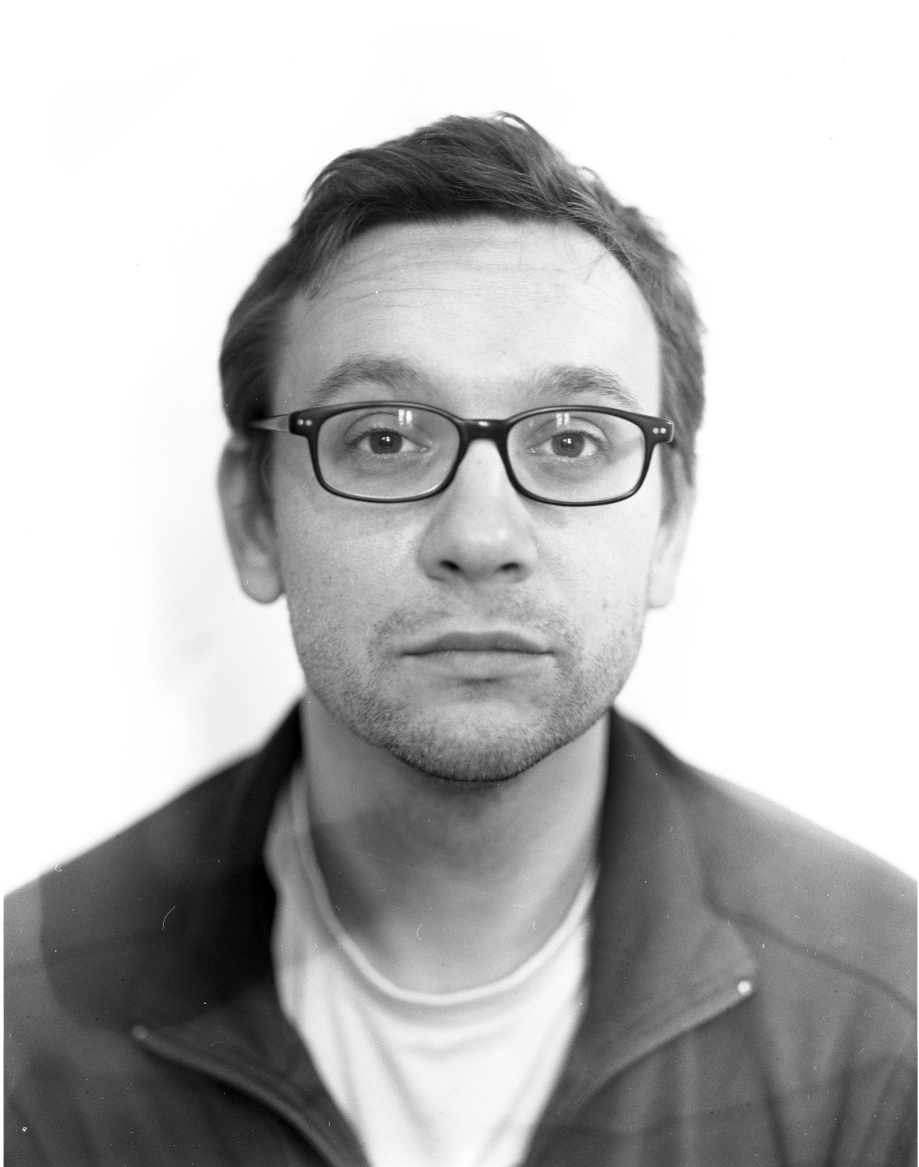 Black and white portrait photograph of a man wearing glasses.