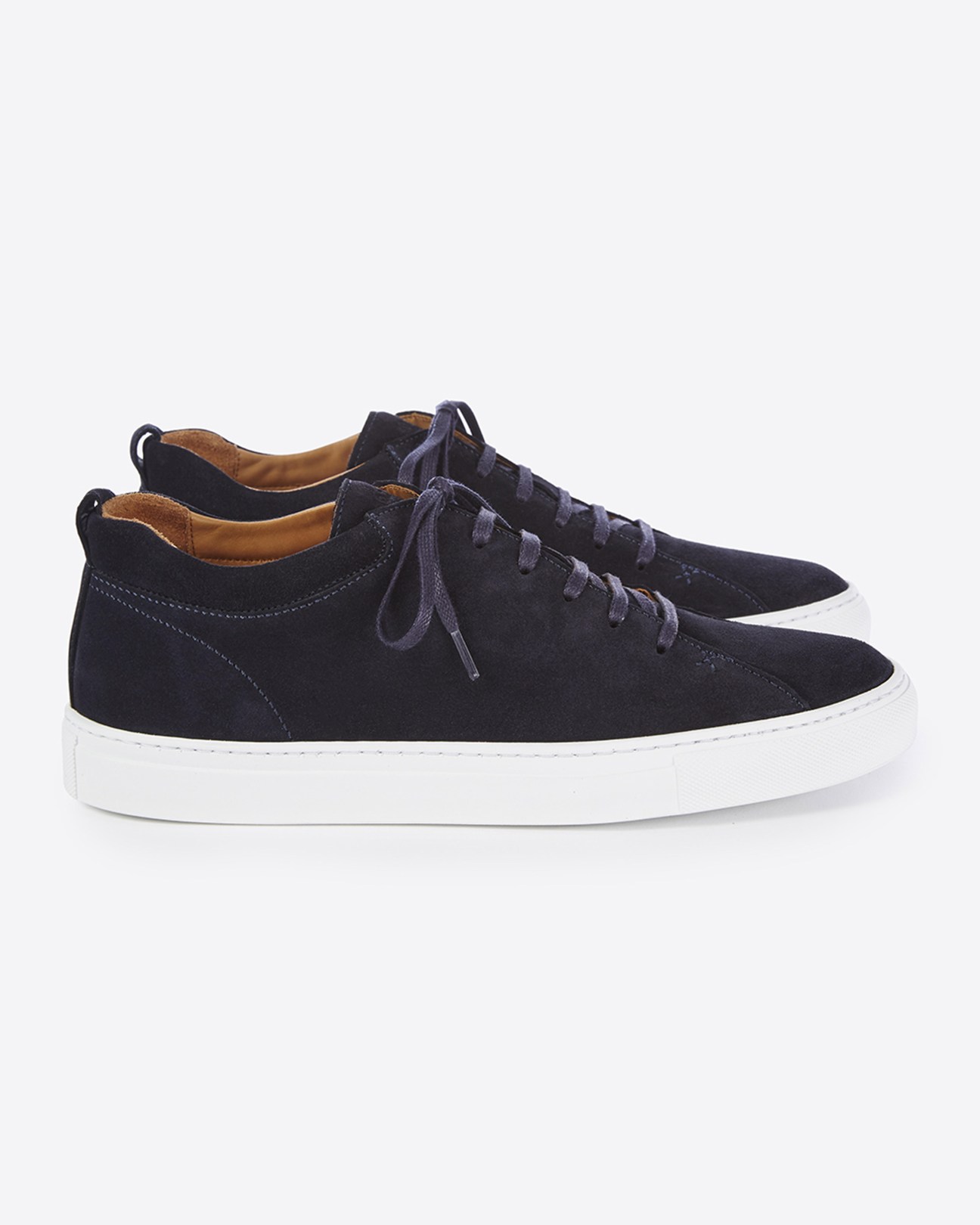 Navy suede sneaker with white rubber sole and brown leather lining displayed against white background.