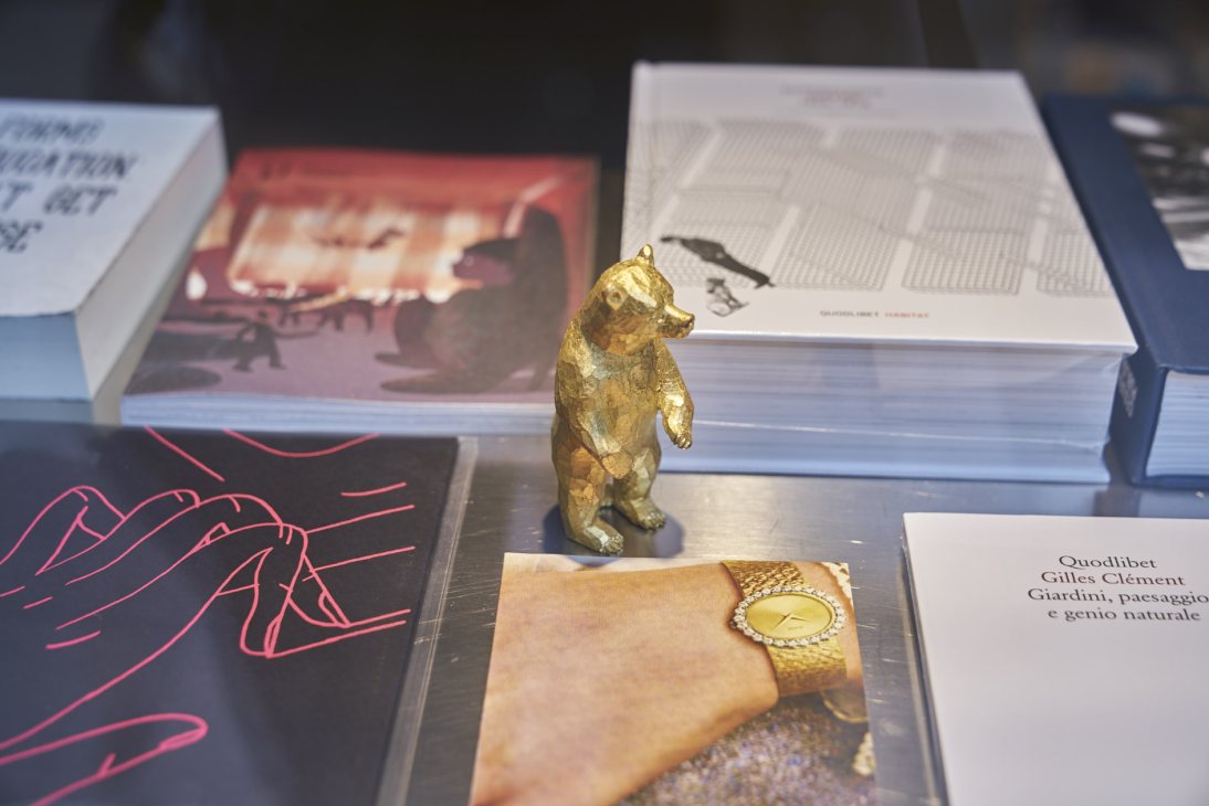 Interior of Bruno design studio and bookshop in Venice displaying art books, a golden bear figurine, and other design objects.