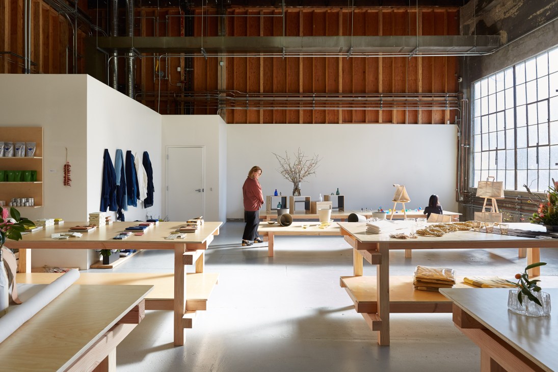 Interior of Playmountain East design shop in San Francisco showing wooden tables and shelves displaying products.
