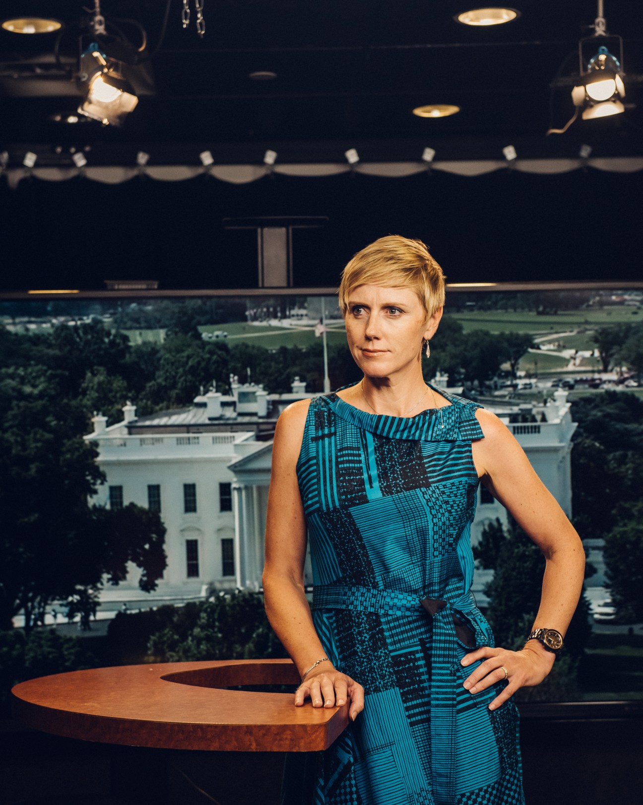 Zoe Daniel stands in a television studio with the White House visible in the background window.
