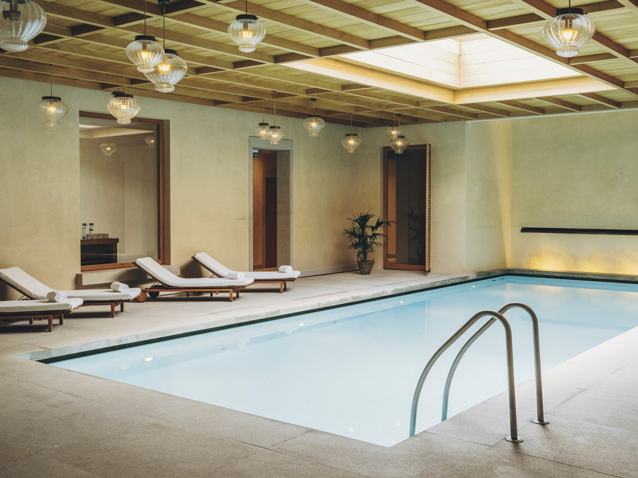Serene indoor swimming pool area with stone architecture and spa facilities