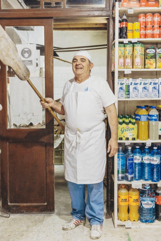 Baker Toño Sieira working with bread in front of the historic wood-fired oven at Sieira Charlin bakery