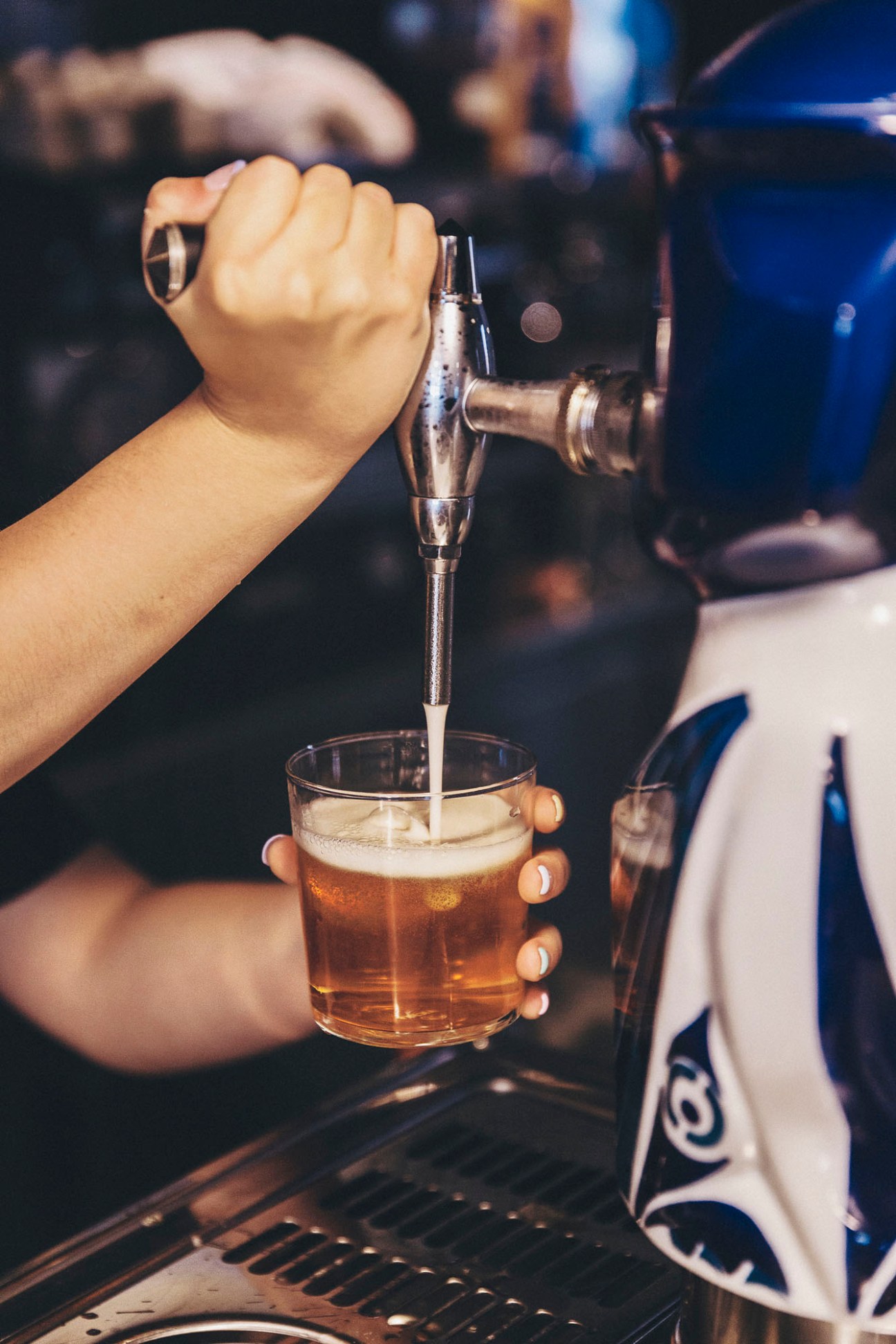 Hand pouring a glass of Estrella Galicia beer at Bar do Porto
