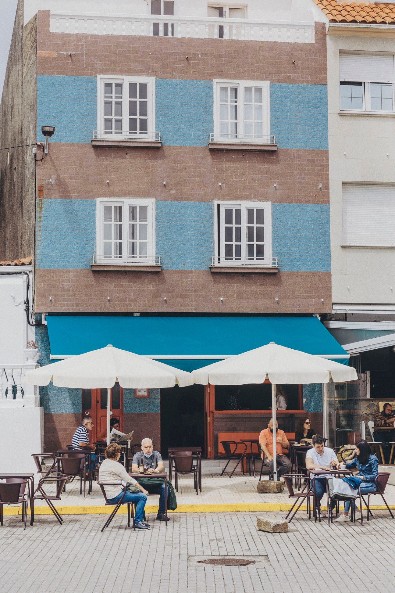 Bar do Porto's outdoor terrace with tables and chairs extending onto the village street