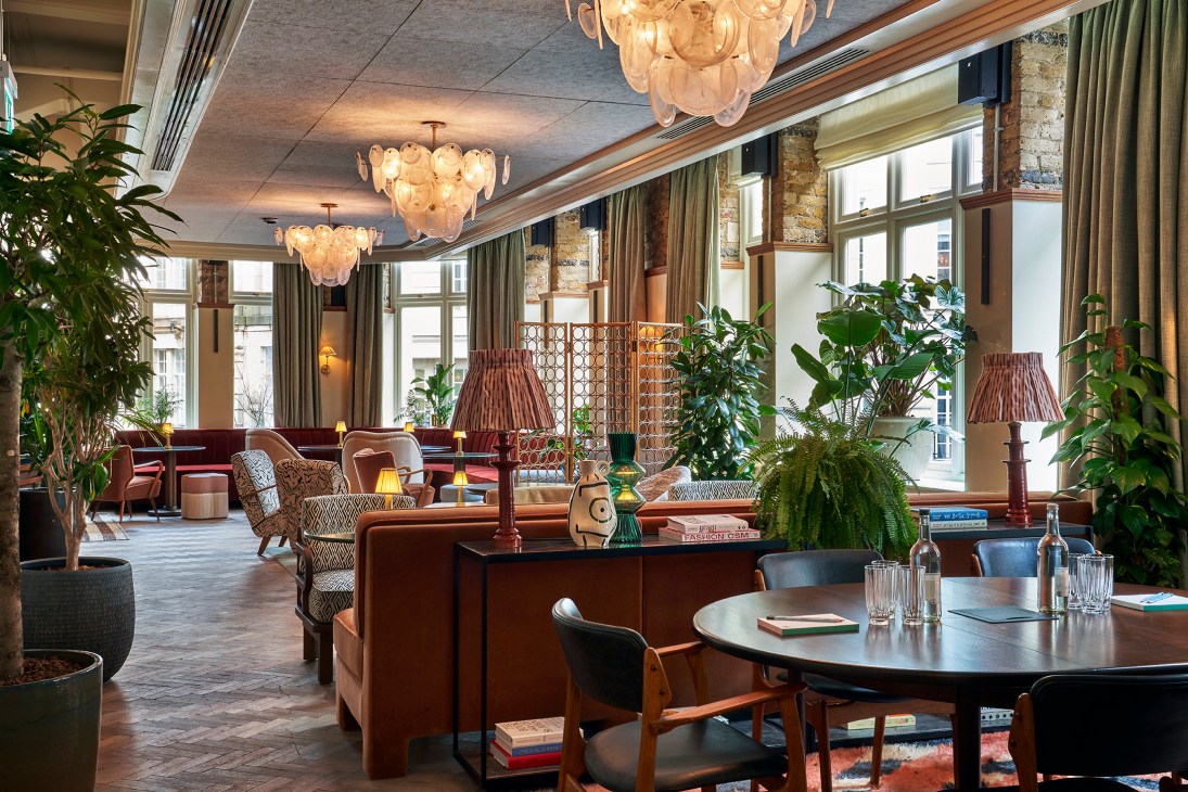Elegant interior of 1 Warwick members club with comfortable seating, chandeliers, and large windows