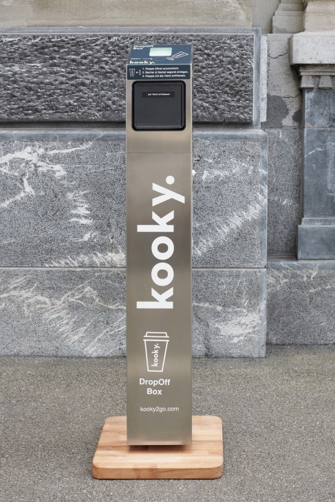 Kooky reusable coffee cup drop-off box with contactless return slot on a street.