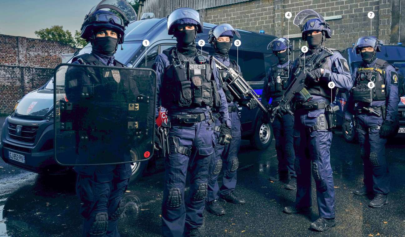 French CRS 8 riot police officer wearing protective gear and carrying equipment