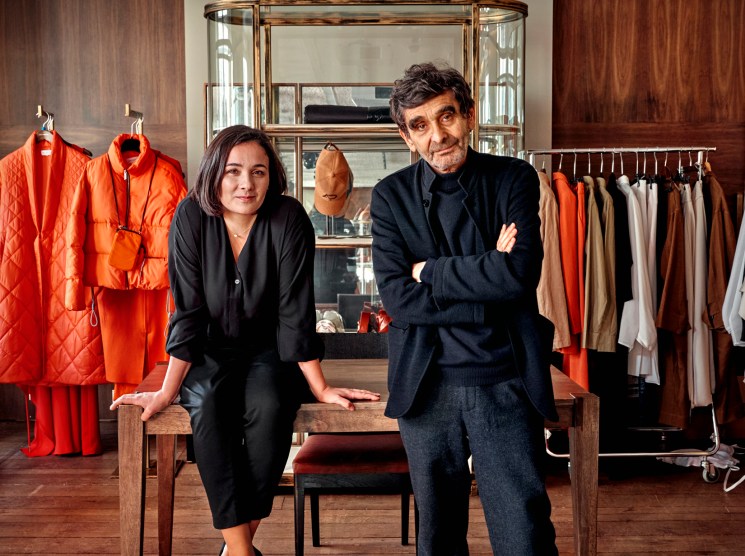 Adolfo and Adriana Domínguez sitting together in a fashion showroom with clothing displays