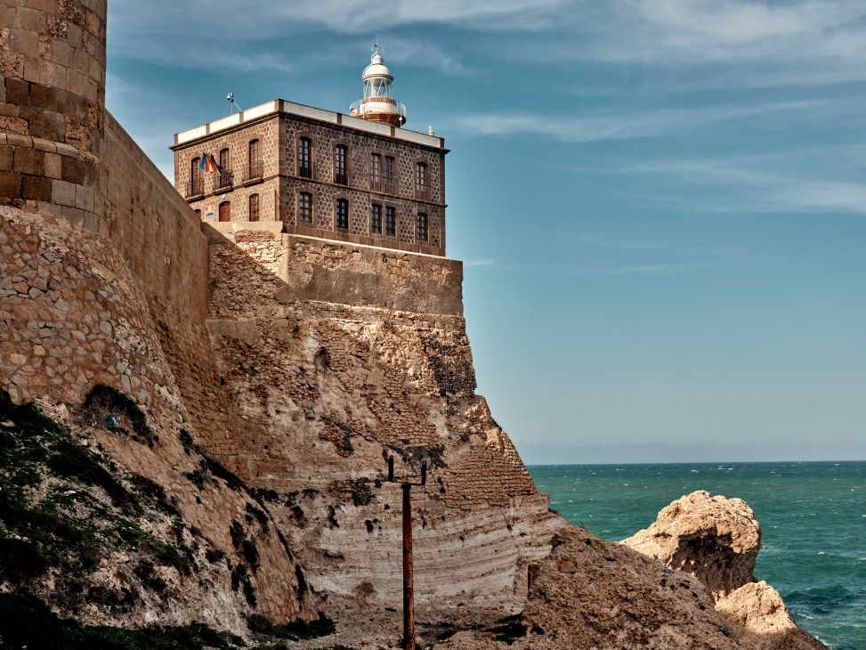 Historic stone fortress walls and lighthouse of Melilla la Vieja complex overlooking the Mediterranean Sea