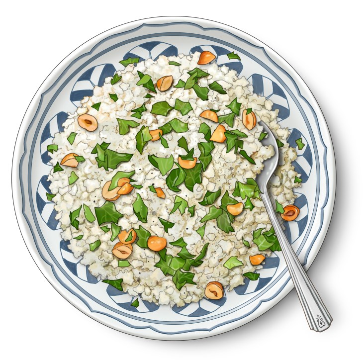 Fresh cauliflower salad with mint and roasted hazelnuts arranged on white plate