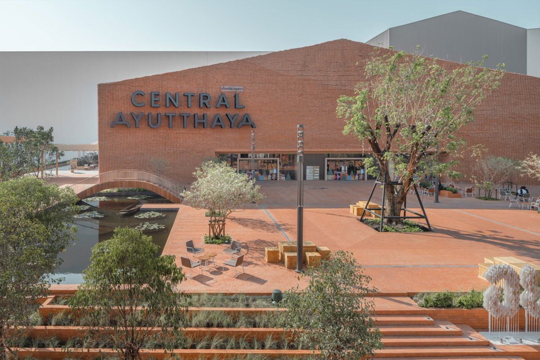 Central Ayutthaya shopping center exterior with brick facade, landscaped plaza, water features and pedestrian bridge